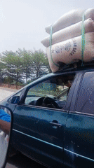 Overloaded minivan transports white sacks in Gora, Nigeria