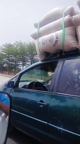 Overloaded minivan transports white sacks in Gora, Nigeria