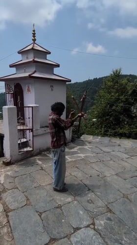 Person observed at small temple structure in Haini, India