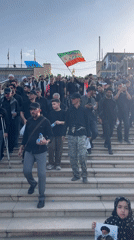 Crowd descends stone stairs during Iranian public gathering