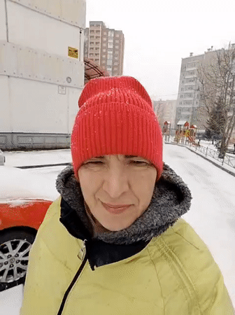 Woman in winter clothing observed during snowfall in Krasnoyarsk