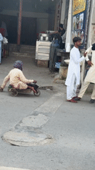 Man on homemade cart observed during street traffic in Multan