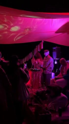 Late-night outdoor music event under glowing canopy in Shebanovo