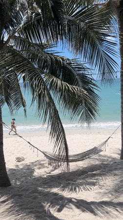 Woman walks tropical beach in Vietnam coastal scene