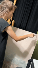 Artist works on large painting in Cape Coral studio