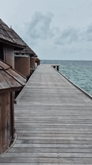 Wooden boardwalk with traditional huts captured in Maldives