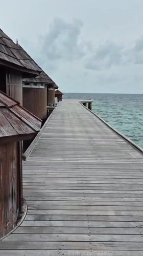 Wooden boardwalk with traditional huts captured in Maldives