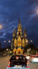 Illuminated church spires glow against Brussels evening sky