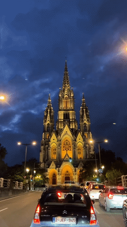 Illuminated church spires glow against Brussels evening sky