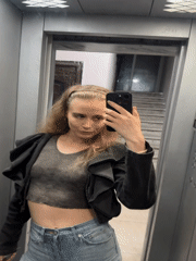 Woman takes elevator selfie, indoor walking captured nearby