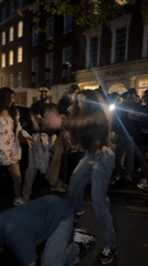 Young adults dance, socialize on London street Saturday evening