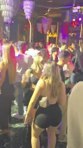 Late-night Milan club scene with neon lights and Dom Perignon