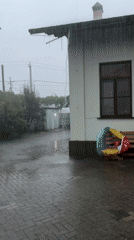Heavy downpour hits a garden courtyard, caught from multiple angles.
