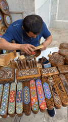 Traditional woodcarver works near historic Samarkand architecture