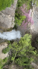 Drone captures Tbilisi waterfall and classical statue during afternoon