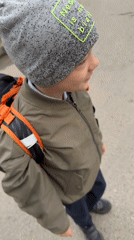 Boy in distinctive beanie spotted smiling outdoors in Dmitrov