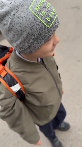 Boy in distinctive beanie spotted smiling outdoors in Dmitrov