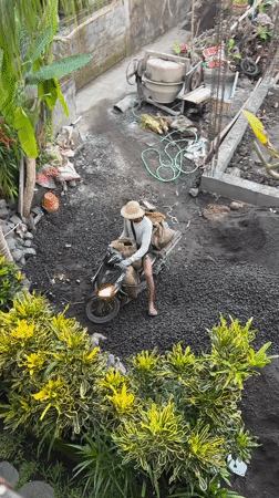 Barefoot scooter rider navigates construction zone in Ubud