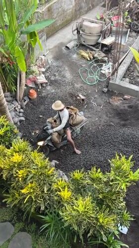 Barefoot scooter rider navigates construction zone in Ubud