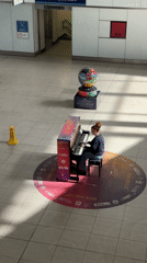 Piano performance and transport activity at London underground station