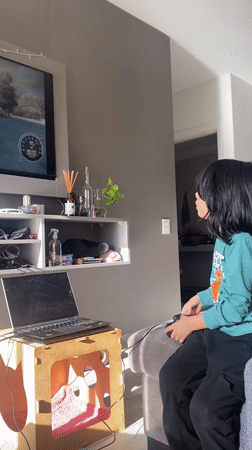 Young gamer plays racing video game in Buenos Aires