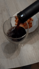 Woman enjoys red wine at indoor gathering in Klin