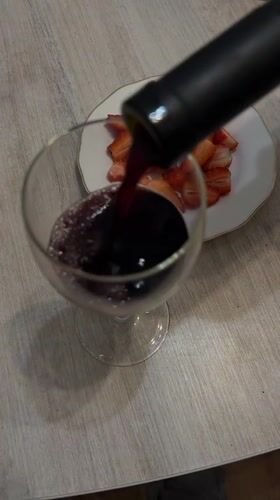 Woman enjoys red wine at indoor gathering in Klin