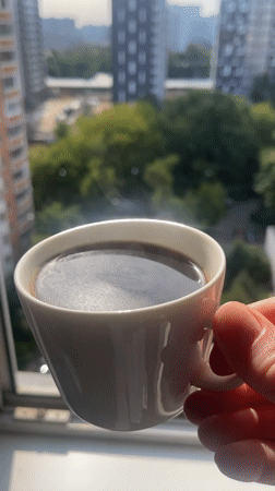 Hot coffee by the window, steam rising from a white mug.