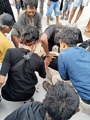 Group assists person on ground in public area
