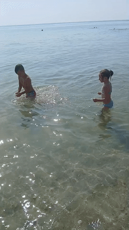 Calm summer morning at Kranevo beach, kids in the shallows