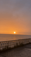 Woman captures sunset selfie along Sochi's oceanfront balustrade