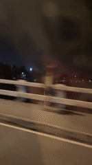 Nighttime cyclist crosses bridge in Davao City, Philippines