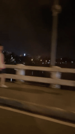 Nighttime cyclist crosses bridge in Davao City, Philippines