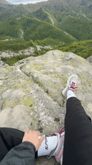 Hiker rests on rocky summit overlooking Bulgarian mountain forests