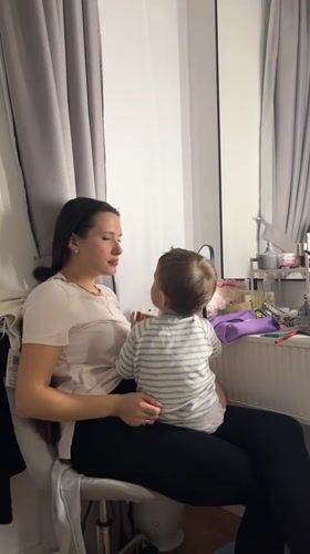 Woman holds child on chair in Russian town