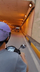 Motorcyclist rides through illuminated tunnel in Hà Nội