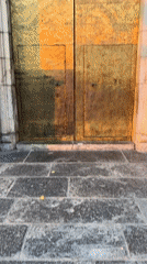 Ornate golden door on a carved stone building in Jérica