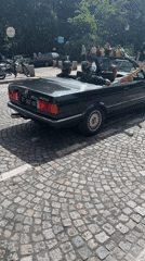 Group gathers with BMW convertible on Paris cobblestone street