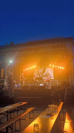 Live band, pink food truck, and evening crowd at outdoor festival