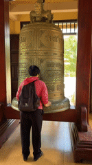 Early morning temple visitors observe ancient bell in Da Lat