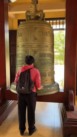 Early morning temple visitors observe ancient bell in Da Lat