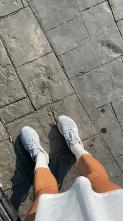 Person in grey sneakers filmed on paved surface in Thailand