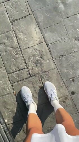 Person in grey sneakers filmed on paved surface in Thailand