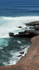 Waves crash against rocky coastline near Tinajo, Spain