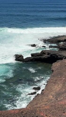 Waves crash against rocky coastline near Tinajo, Spain