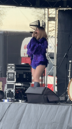 Woman performs in sequined outfit on outdoor stage in Norwich