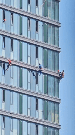 Window cleaners work the exterior of a Moscow glass skyscraper