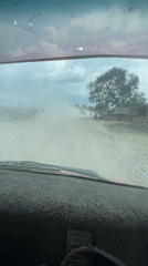 Vehicle crosses dusty roads and bridge during afternoon journey