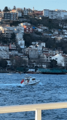 Turkish flagged boat sails past Beşiktaş waterfront