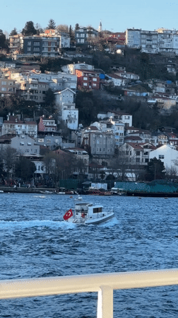Turkish flagged boat sails past Beşiktaş waterfront